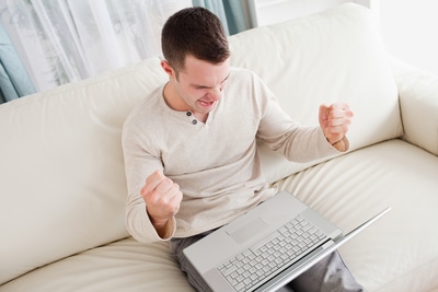 man sitting on the couch with laptop on his lap