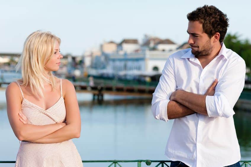 couple looking at each other with arms crossed