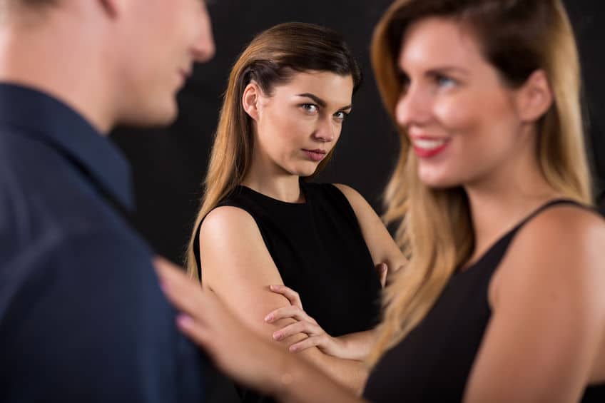 woman looking to the couple with her arms crossed