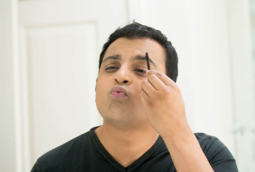A guy brushing his eyebrow