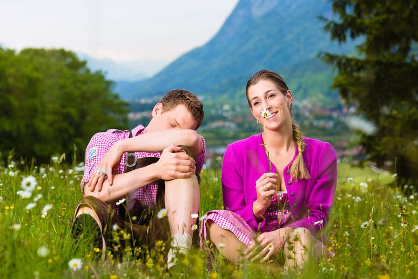 two young couple sitting on the grass both wearing purple colored clothes