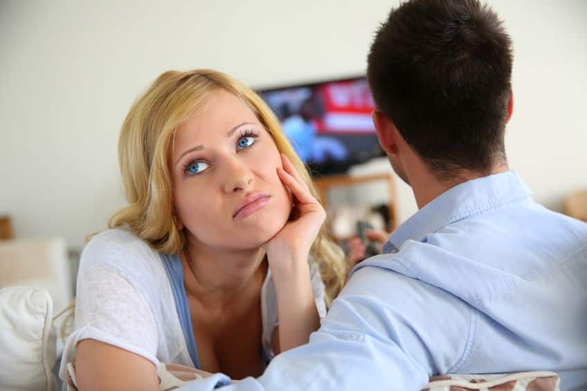 bored woman with her partner watching television