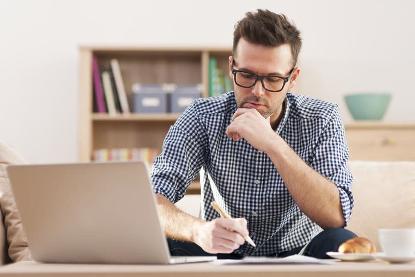 man with glasses writing