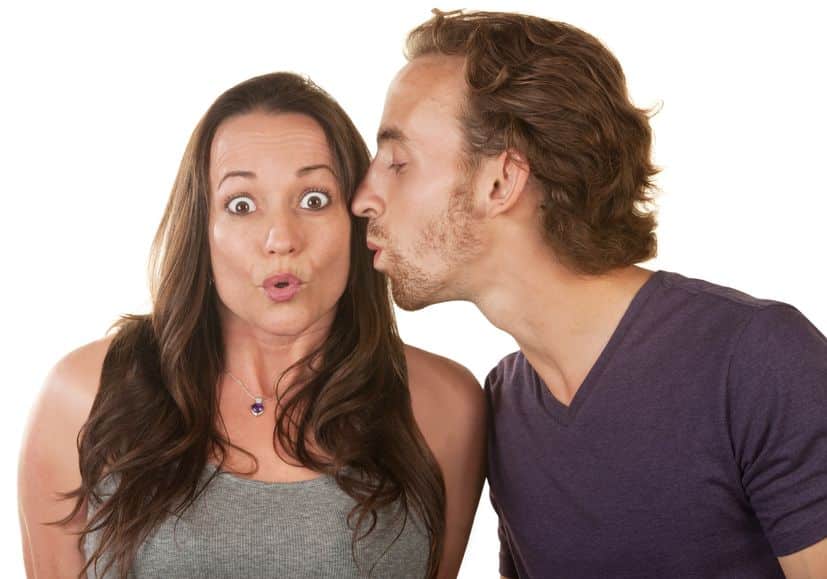 A man trying to kiss a woman on the cheek