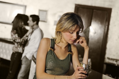 Woman wearing green sleeveless top thinking about his husband cheating