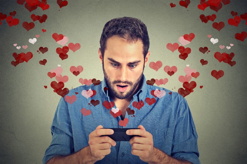 surprised young man finding love with his mobile phone