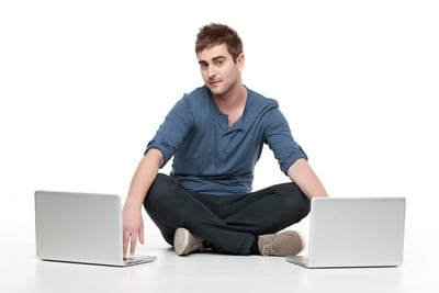 young man in between two laptops