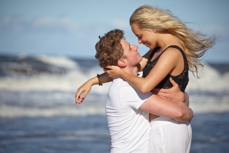 romantic couple close together at the beach