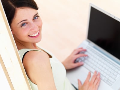 a happy young woman using her laptop