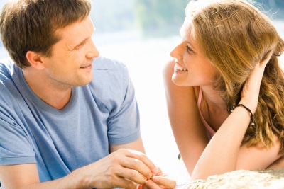 a young couple looking at each other while smiling