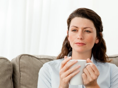 woman deeply thinking while drinking coffee