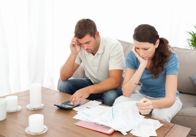 Desperate couple doing their accounts sitting on the sofa at home