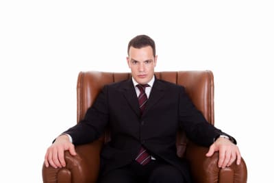 businessman sitting on a chair, looking seriously