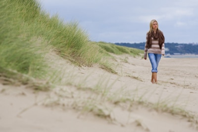 woman walking alone along a deserted beach