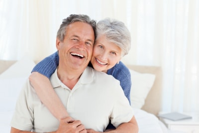 old couple looking happy in a hug