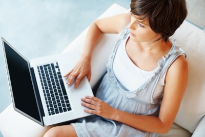 Top view of young woman chatting on laptop at home