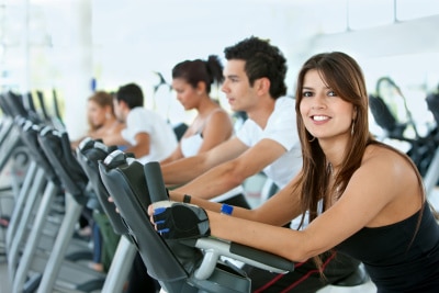 Group of gym people exercising on cardio machines