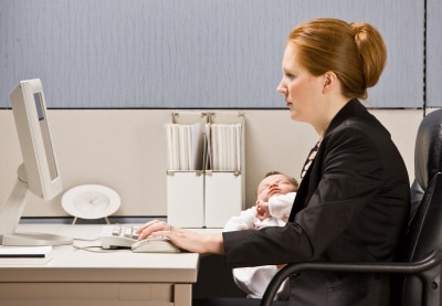 working mom in the office carrying her baby