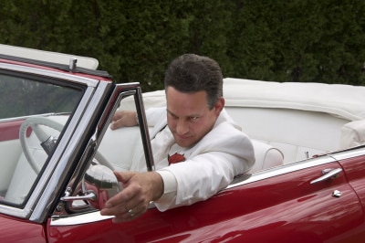 narcissistic man looking at his red cars mirror