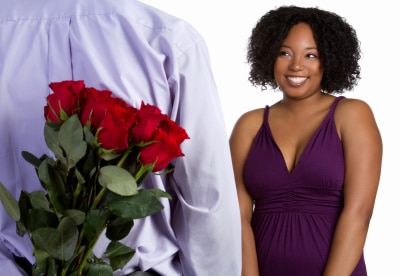 man bringing red roses and courting a black beautiful woman