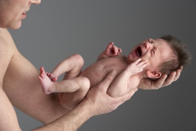 a new-born child carried by his father