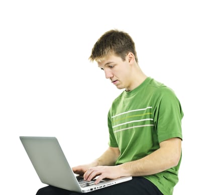 Serious young man sitting with laptop computer isolated on white background