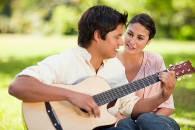 Man playing a guitar to his girlfriend