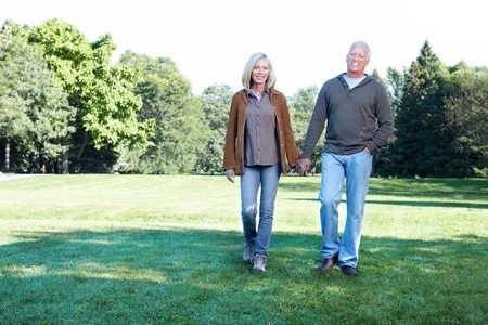 happy matured couple holding hands while walking at the park