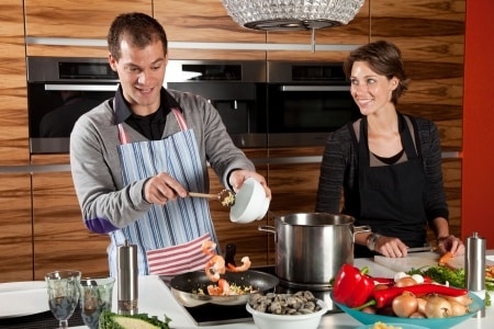 husband and wife cooking together in the kitchen