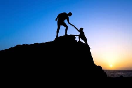 couple climbing up a mountain to see the beautiful sunrise