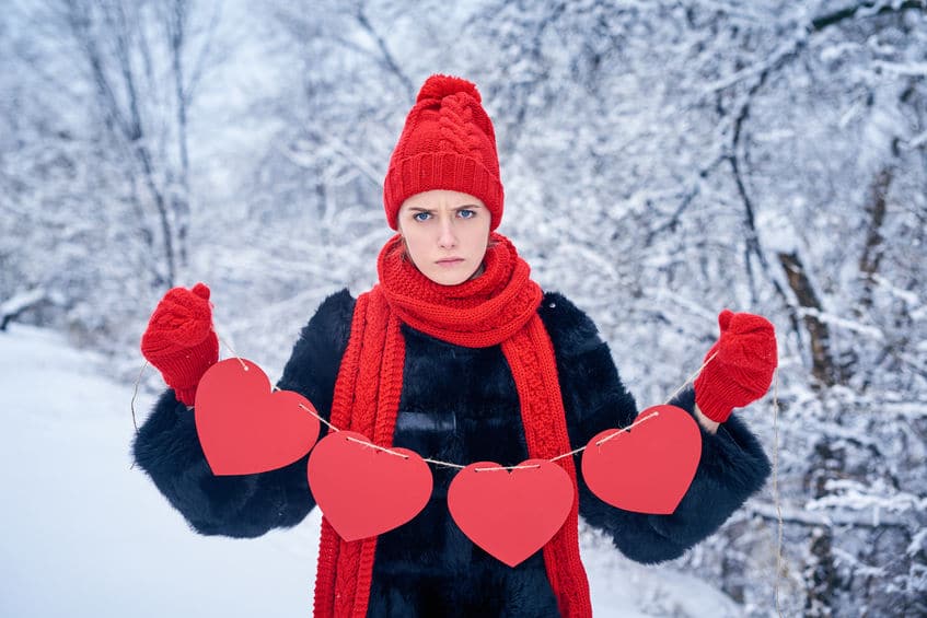 Woman holding paper crafted hearts thinking of what to do on valentines day