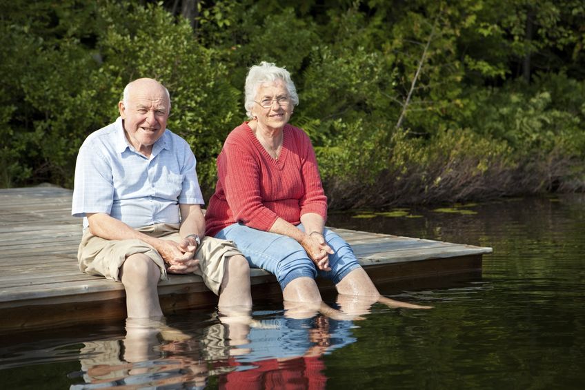 old couple sitting and having a great time in the lake