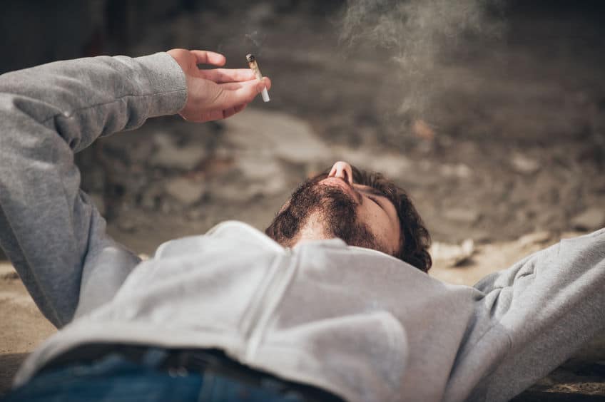 guy lying on the floor while smoking