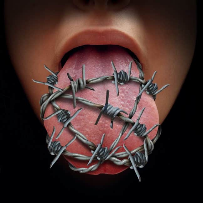 Freedom of speech crisis concept and censorship in expression of ideas symbol as a human tongue wrapped in old barbed wire as a metaphor for political correctness pressure to restrain free talk or limit communication.