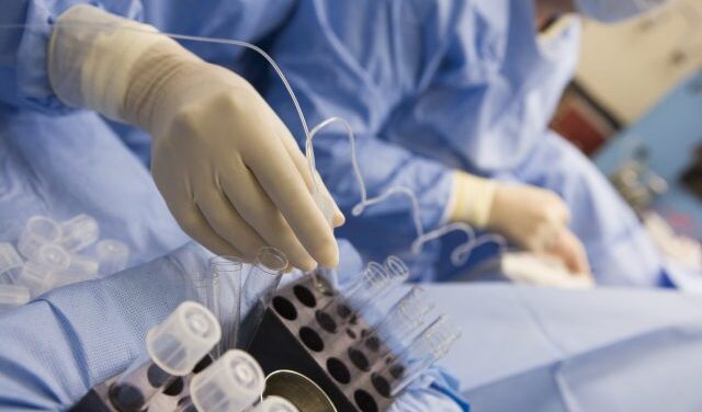 Nurse assisting with egg retrieval procedure in theatre