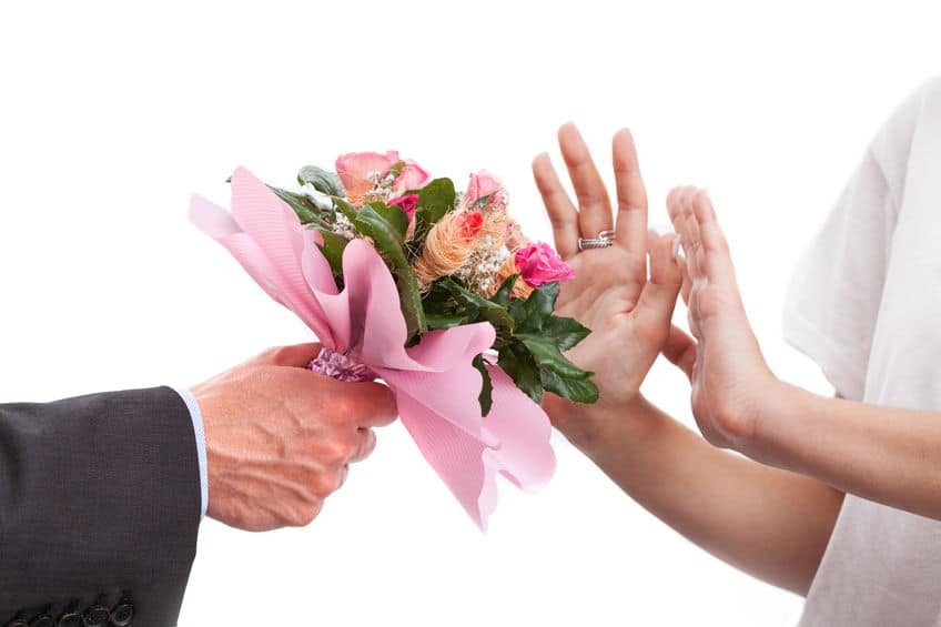 woman rejecting flowers from a guy