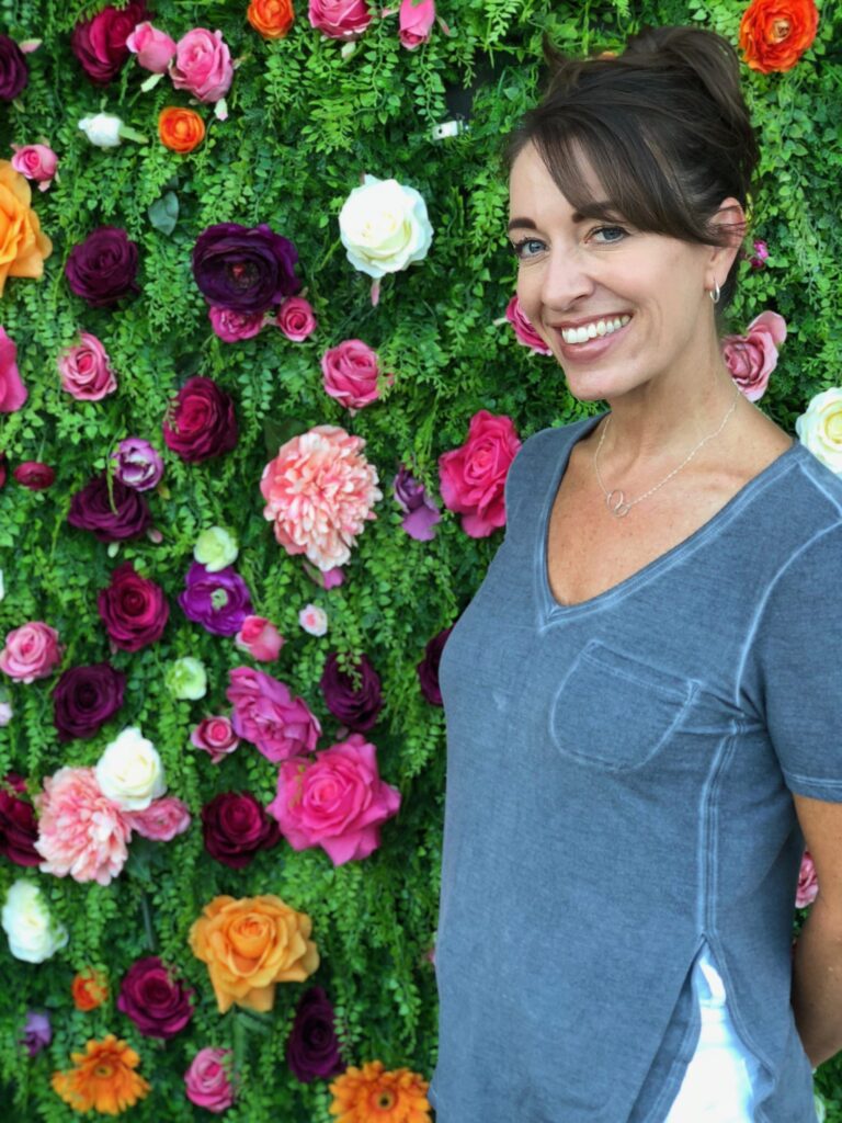 lovely woman taking a picture with a beautiful background with lots of flowers