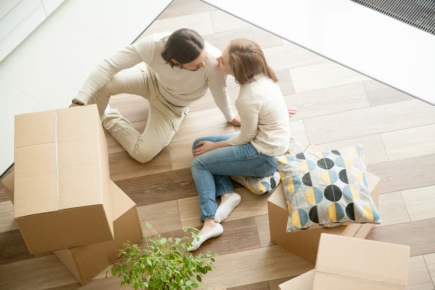 Couple sitting on floor with boxes, moving day, top view