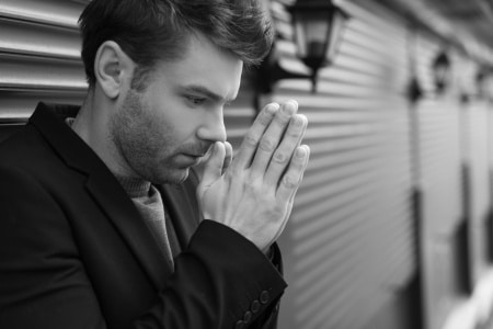 black and white photo of a guy with closed palms