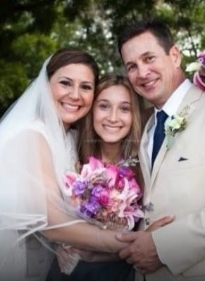 a middle-aged couple getting married with their teen-aged daughter