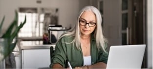 a woman employee working with her laptop and notes