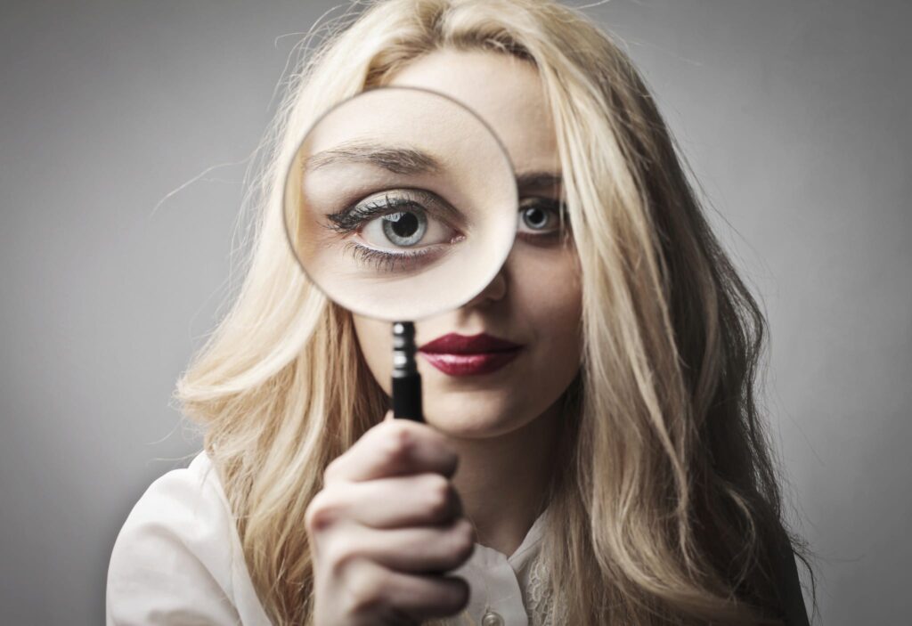 Young woman holding a magnifying glass