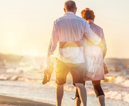 Evan Marc Katz Focus Coaching couple walking on the beach wearing white