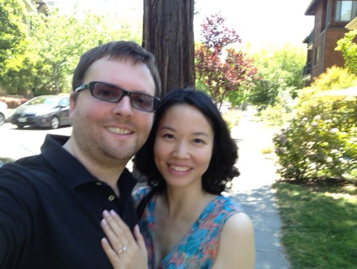 young couple taking picture while walking on the pavement