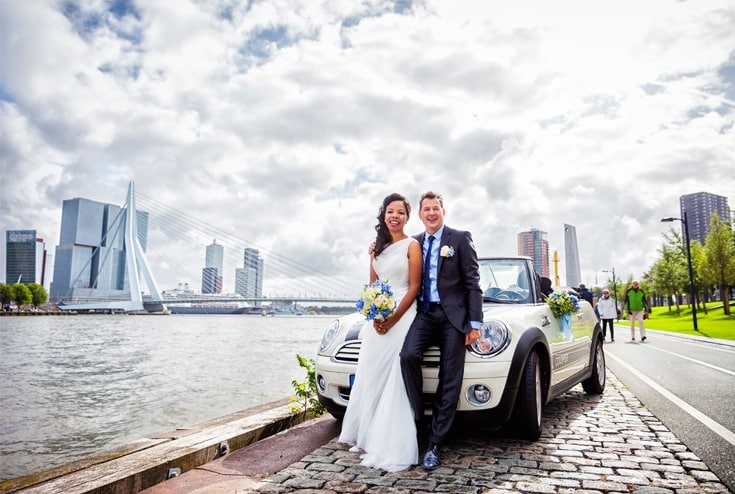 newly-wed couple on their wedding car by the lake