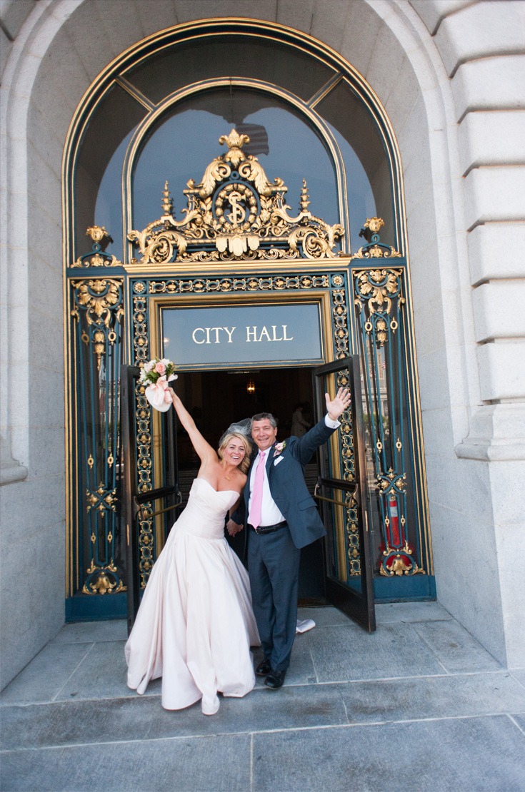 happily married couple at the entrance of the city hall