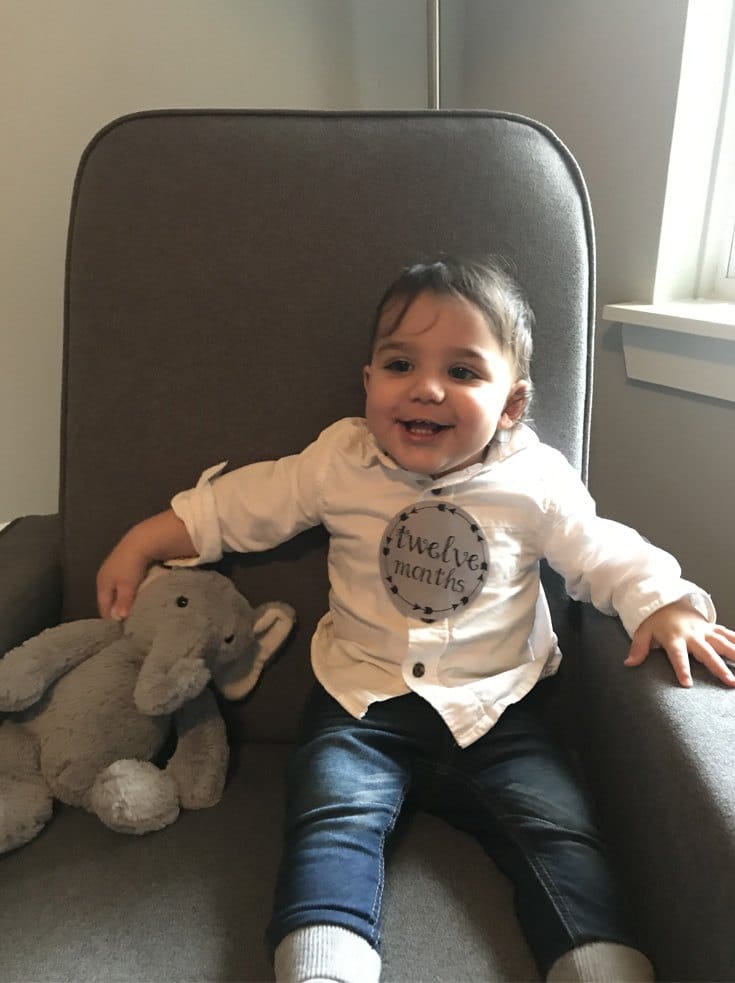 a cute baby on a couch with his toy elephant