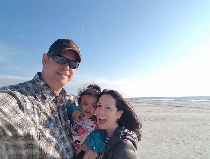 a couple with their baby on the beach