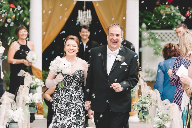 newly-wed couple walking down the isle full of bubbles