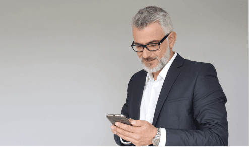 handsome older man wearing glasses checking his smartphone